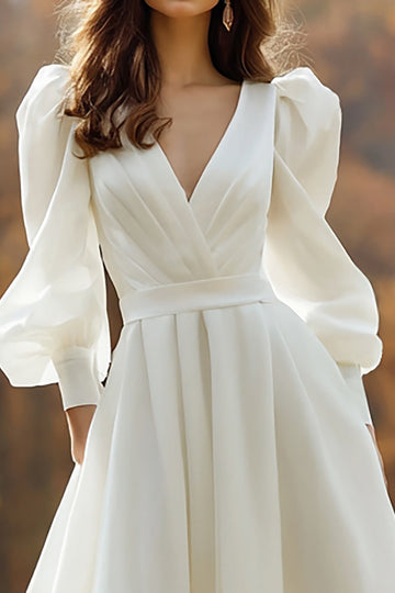 Une robe de mariée à manches longues ivoire à col en V